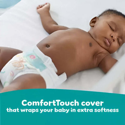 Baby lying on a white blanket with a ComfortTouch diaper cover, text overlay about extra softness.