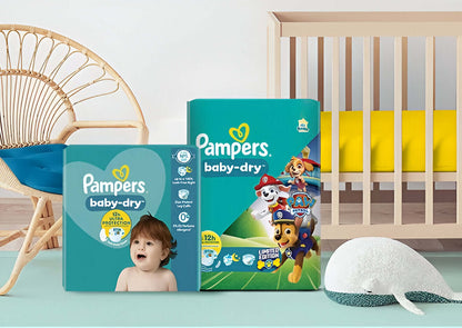 Pampers baby-dry diapers packaging with Paw Patrol characters in a nursery setting.
